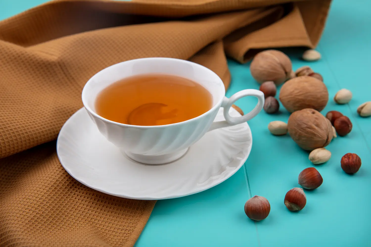 Cup of herbal tea with a small bowl of nuts, perfect for a relaxing evening wind-down