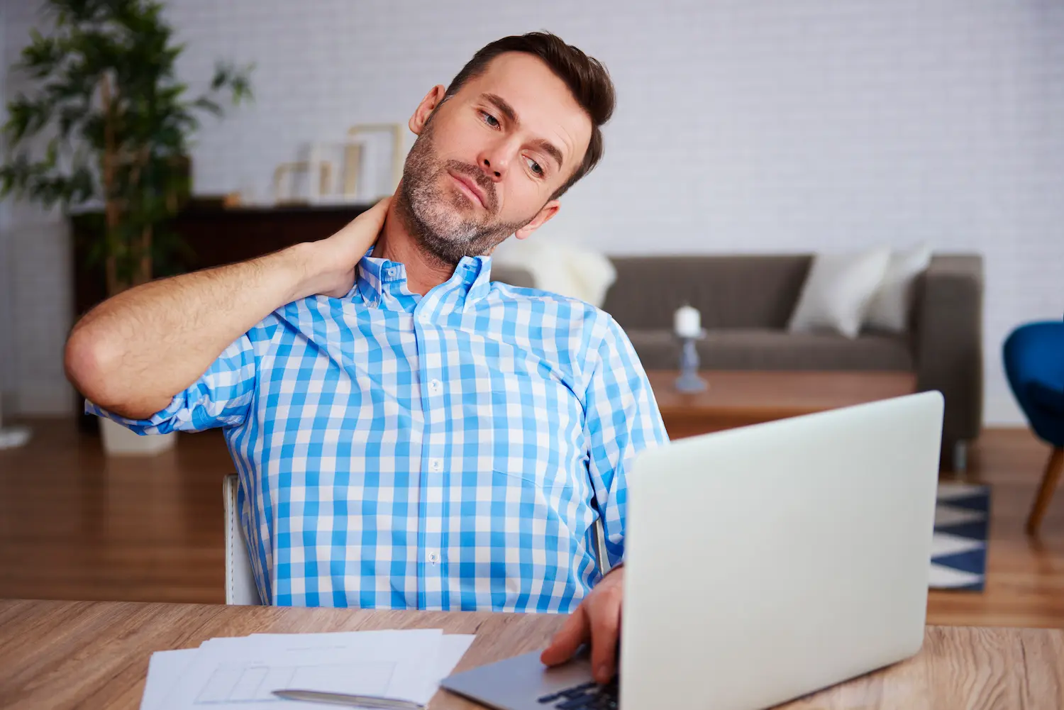 A desk worker gently stretching their neck with relaxed posture.