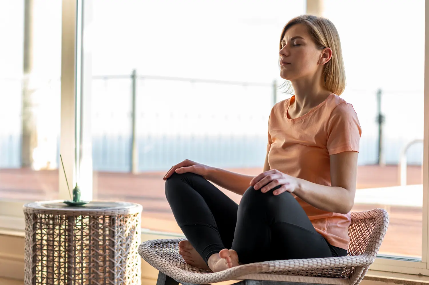 A remote worker sitting calmly by a window, ready to begin a mindful breathing exercise